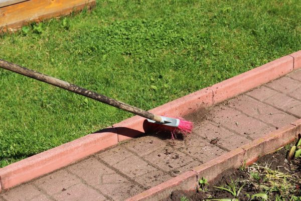 Cleaning paths in the garden by brush